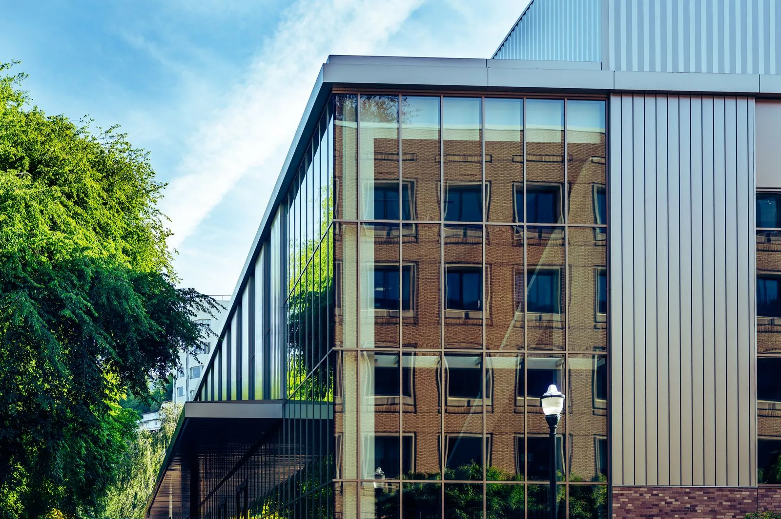 An office building's glass facade reflecting the buildings around it